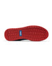 Men's Field V2 Shoe in Camo Indigo, bottom sole view featuring a red rubber outsole with multi-directional traction lugs and a blue branded logo badge
