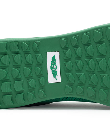 Men's Field V2 Shoe in Green, close-up outsole view featuring a green rubber outsole with multi-directional traction lugs and a white branded logo badge