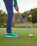 Men's Field V2 Shoe in Green, on-course lifestyle view featuring a golfer putting on the green
