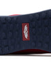 Men's Field V2 Shoe in Red, close-up outsole view featuring a navy rubber outsole with multi-directional traction outsole and a red branded logo badge