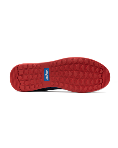 Men's Field V2 Shoe in Camo Indigo, bottom sole view featuring a red rubber outsole with multi-directional traction lugs and a blue branded logo badge