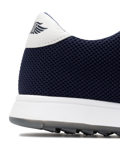 Men's Field V2 Shoe in Indigo, close-up heel detail view featuring the navy mesh knit upper, white heel tab with SD wing logo, and white midsole
