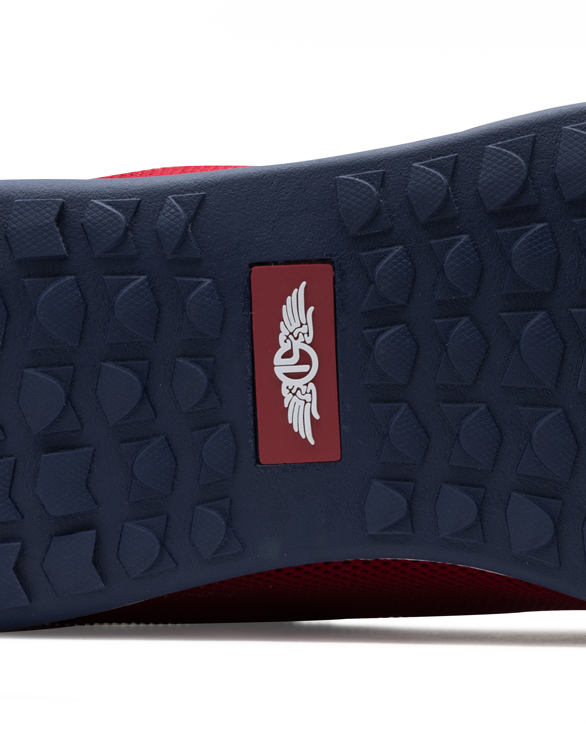 Men's Field V2 Shoe in Red, close-up outsole view featuring a navy rubber outsole with multi-directional traction outsole and a red branded logo badge