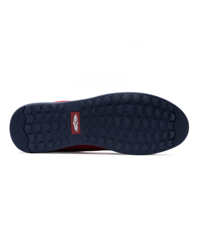 Men's Field V2 Shoe in Red, bottom sole view featuring a navy rubber outsole with multi-directional traction lugs and a branded logo badge