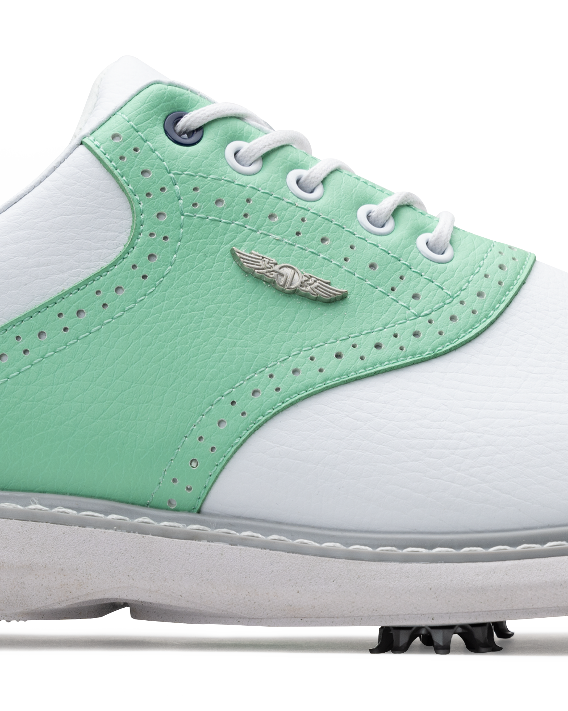 A close-up of a white and mint green golf shoe with white laces, perforated details, a silver wing logo.