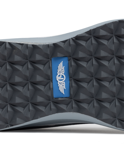 Straight Down Mojave Shoe in Camo Carbon, close-up bottom view of the dark grey geometric textured outsole with Straight Down logo tab in blue