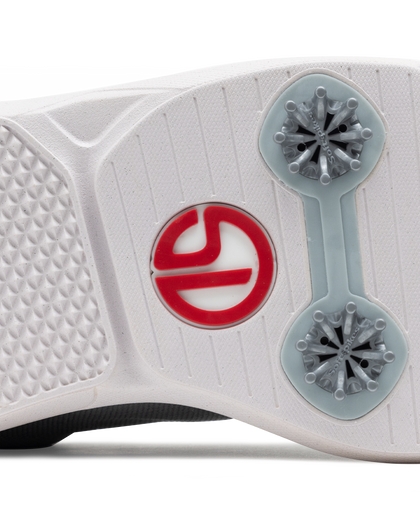 Close-up of a white athletic shoe sole showing a red Straight Down logo and gray spiked outsole details on a white background.