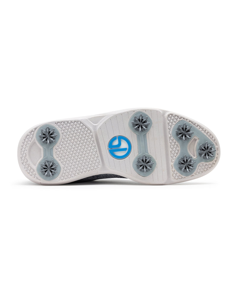 Men's Challenger Shoe in Carbon, bottom sole view featuring a white rubber outsole with gray spike cleats, textured traction zones, and a blue and white branded logo badge
