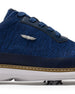 Men's Challenger Shoe in Indigo, close-up side view featuring a navy knit upper highlighting the silver wing logo badge, navy leather lace stay, and tan welt stitch detail with white midsole and spiked outsole