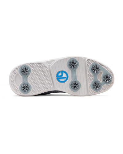 Men's Challenger Shoe in Carbon, bottom sole view featuring a white rubber outsole with gray spike cleats, textured traction zones, and a blue and white branded logo badge