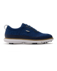 Men's Challenger Shoe in Indigo, side profile view featuring a navy knit upper with navy laces, a silver wing logo badge, navy leather trim, a tan welt stitch detail, white midsole, and spiked outsole