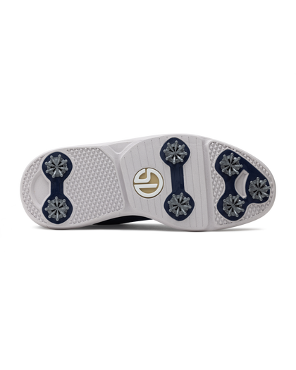 Men's Challenger Shoe in Indigo, bottom sole view featuring a white rubber outsole with navy spike cleats, textured traction zones, and a gold and white branded logo badge