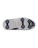 Men's Challenger Shoe in Indigo, bottom sole view featuring a white rubber outsole with navy spike cleats, textured traction zones, and a gold and white branded logo badge