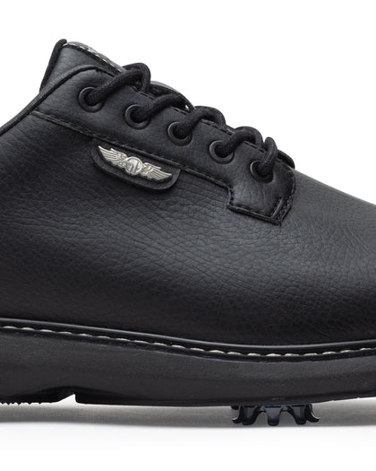 Men's Derby Shoe in Black, close-up side view featuring black pebbled leather upper with silver winged Straight Down logo badge on tongue tab, black lacing system, contrast stitch midsole trim, and spiked outsole