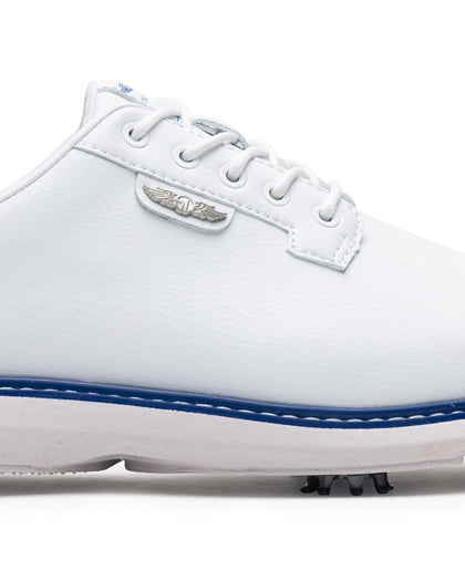 Men's Derby Shoe in White, close-up side view featuring white leather upper with silver winged Straight Down logo badge on tongue tab, white lacing system, royal blue midsole trim accent, and spiked outsole