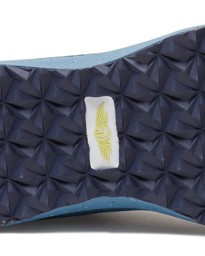 Men's Moonlight V2 Shoe in Deep Sea, close-up bottom view featuring a navy geometric pyramid-textured rubber outsole with a centered white and gold Straight Down logo badge and speckled light blue midsole edge