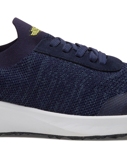 Straight Down Weekender Golf Shoe in New Indigo, close-up lateral side detail view featuring navy knit upper, yellow Straight Down wing logo on tongue, navy laces, and white midsole