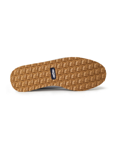 Straight Down Bourbon Hybrid Golf Shoe in White, bottom sole view featuring gum rubber geometric pyramid traction outsole with navy Straight Down wing logo badge at arch
