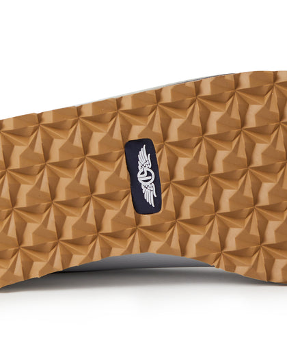 Straight Down Bourbon Hybrid Golf Shoe in White, close-up outsole detail view featuring gum rubber geometric pyramid traction outsole with navy Straight Down wing logo badge at arch