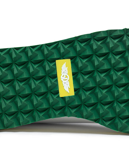 Straight Down Bourbon Hybrid Golf Shoe in White Verde, close-up outsole detail view featuring green geometric pyramid traction outsole with yellow Straight Down wing logo badge at arch