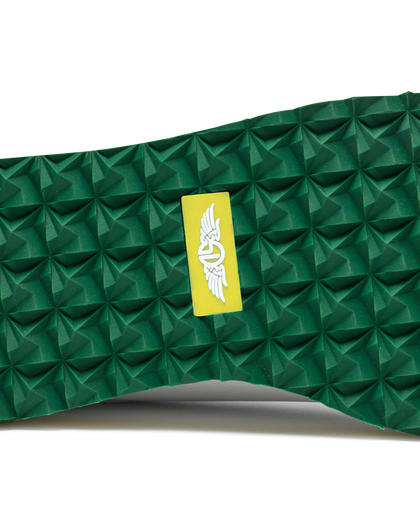 Straight Down Bourbon Hybrid Golf Shoe in White Verde, close-up outsole detail view featuring green geometric pyramid traction outsole with yellow Straight Down wing logo badge at arch
