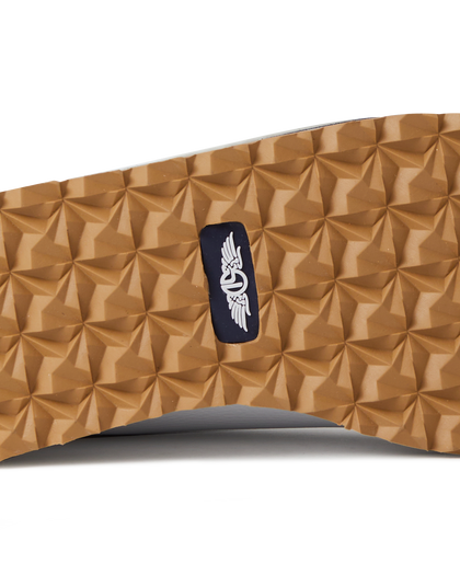 Straight Down Bourbon Hybrid Golf Shoe in White, close-up outsole detail view featuring gum rubber geometric pyramid traction outsole with navy Straight Down wing logo badge at arch