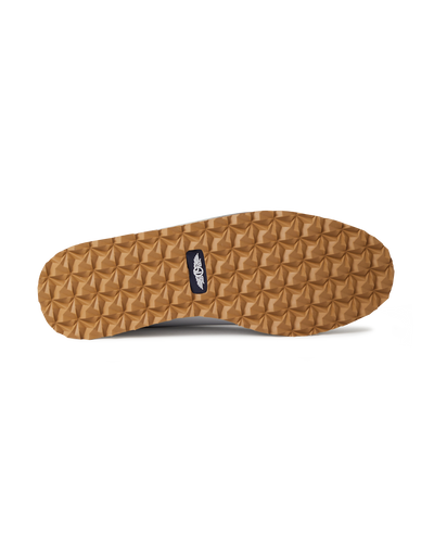 Straight Down Bourbon Hybrid Golf Shoe in White, bottom sole view featuring gum rubber geometric pyramid traction outsole with navy Straight Down wing logo badge at arch