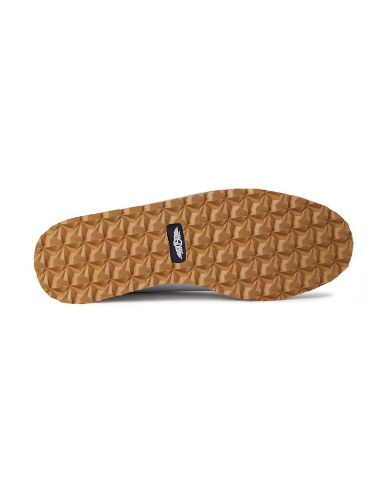 Straight Down Bourbon Hybrid Golf Shoe in White, bottom sole view featuring gum rubber geometric pyramid traction outsole with navy Straight Down wing logo badge at arch