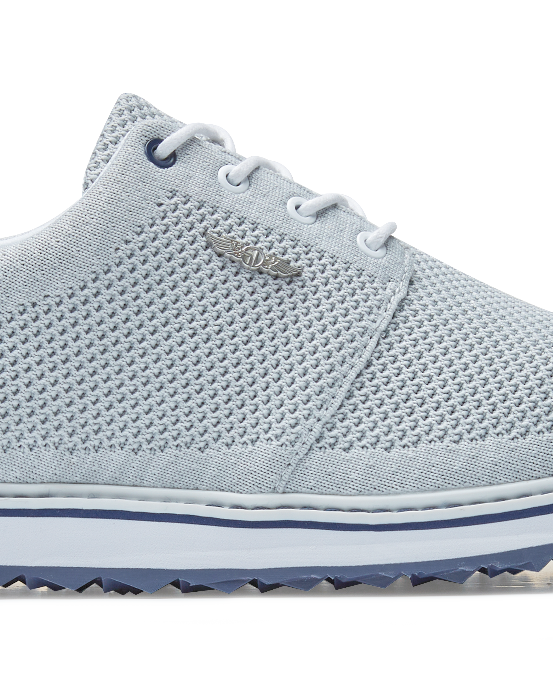 Straight Down Harbour Knit Hybrid Golf Shoe in Silver, close-up lateral side detail view featuring light gray knit upper, silver Straight Down wing logo badge, white laces, and navy stripe midsole accent