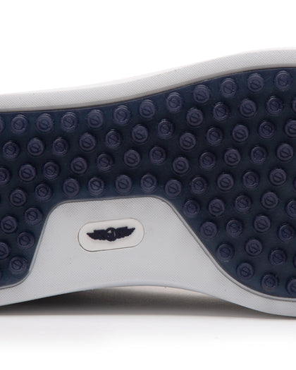 Straight Down Boardwalk Golf Shoe in Petrol, close-up outsole detail view featuring solid navy circular traction nub outsole with white arch bridge and navy Straight Down wing logo badge at center