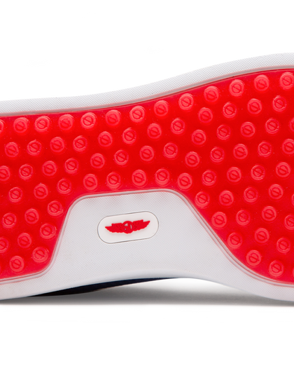 Straight Down Boardwalk Golf Shoe in Federal, close-up outsole detail view featuring solid red circular traction nub outsole with white arch bridge and red Straight Down wing logo badge at center