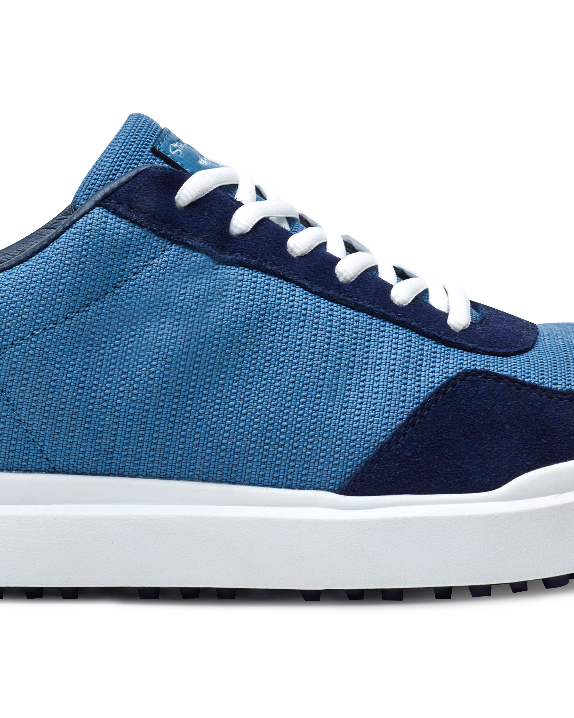 Straight Down Boardwalk Golf Shoe in Petrol, close-up lateral side detail view featuring medium blue canvas upper, navy suede lace overlay and heel panel, white laces, and white outsole