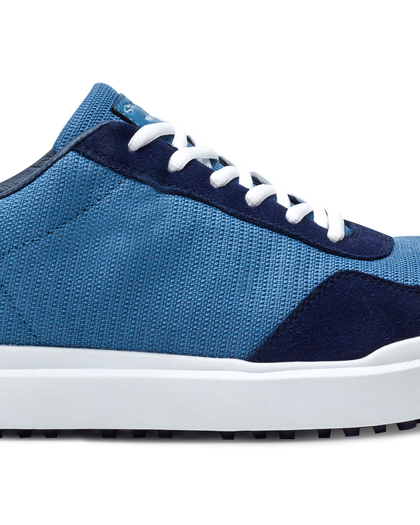 Straight Down Boardwalk Golf Shoe in Petrol, close-up lateral side detail view featuring medium blue canvas upper, navy suede lace overlay and heel panel, white laces, and white outsole
