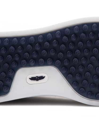 Straight Down Boardwalk Golf Shoe in Petrol, close-up outsole detail view featuring solid navy circular traction nub outsole with white arch bridge and navy Straight Down wing logo badge at center