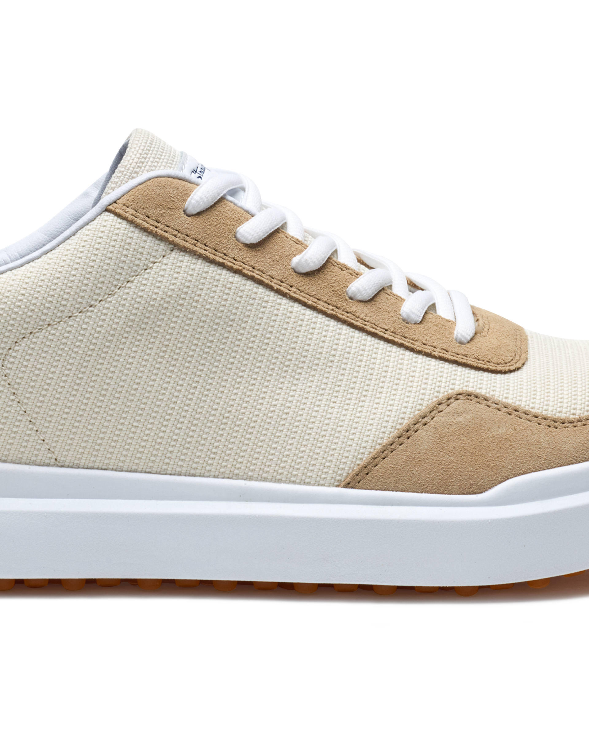 Straight Down Boardwalk Golf Shoe in Stone, close-up lateral side detail view featuring cream canvas upper, tan suede lace overlay and heel panel, white laces, and white outsole