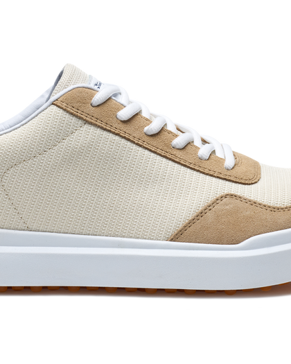 Straight Down Boardwalk Golf Shoe in Stone, close-up lateral side detail view featuring cream canvas upper, tan suede lace overlay and heel panel, white laces, and white outsole