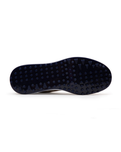 Straight Down Defender Golf Shoe in Camo Stone, bottom sole view featuring navy mixed traction outsole with hexagonal and triangular lugs and white midsole edge