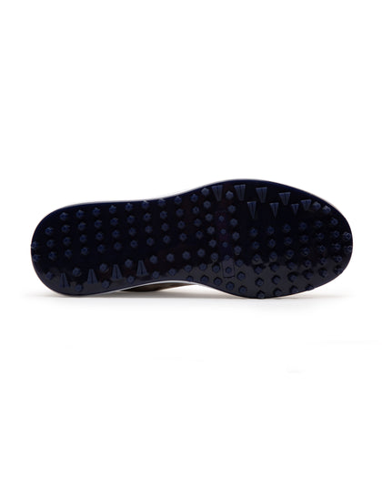 Straight Down Defender Golf Shoe in Camo Stone, bottom sole view featuring navy mixed traction outsole with hexagonal and triangular lugs and white midsole edge