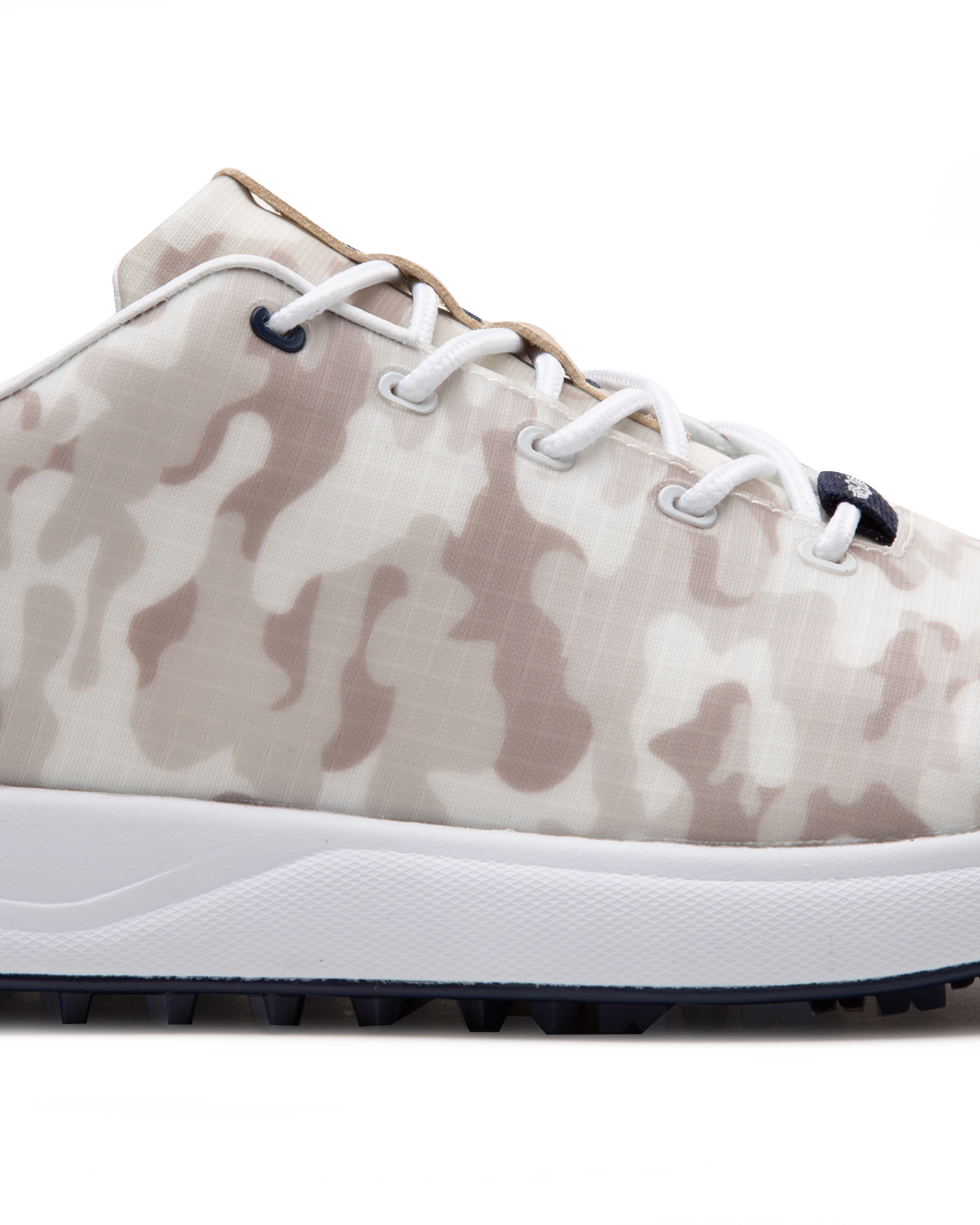 Straight Down Defender Golf Shoe in Camo Stone, close-up lateral side detail view featuring cream and tan desert camouflage print upper, navy lace eyelet accents, white laces, and navy traction outsole