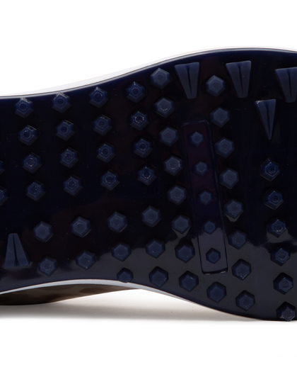 Straight Down Defender Golf Shoe in Camo Stone, close-up outsole detail view featuring navy mixed traction outsole with hexagonal and triangular lug pattern and white midsole edge