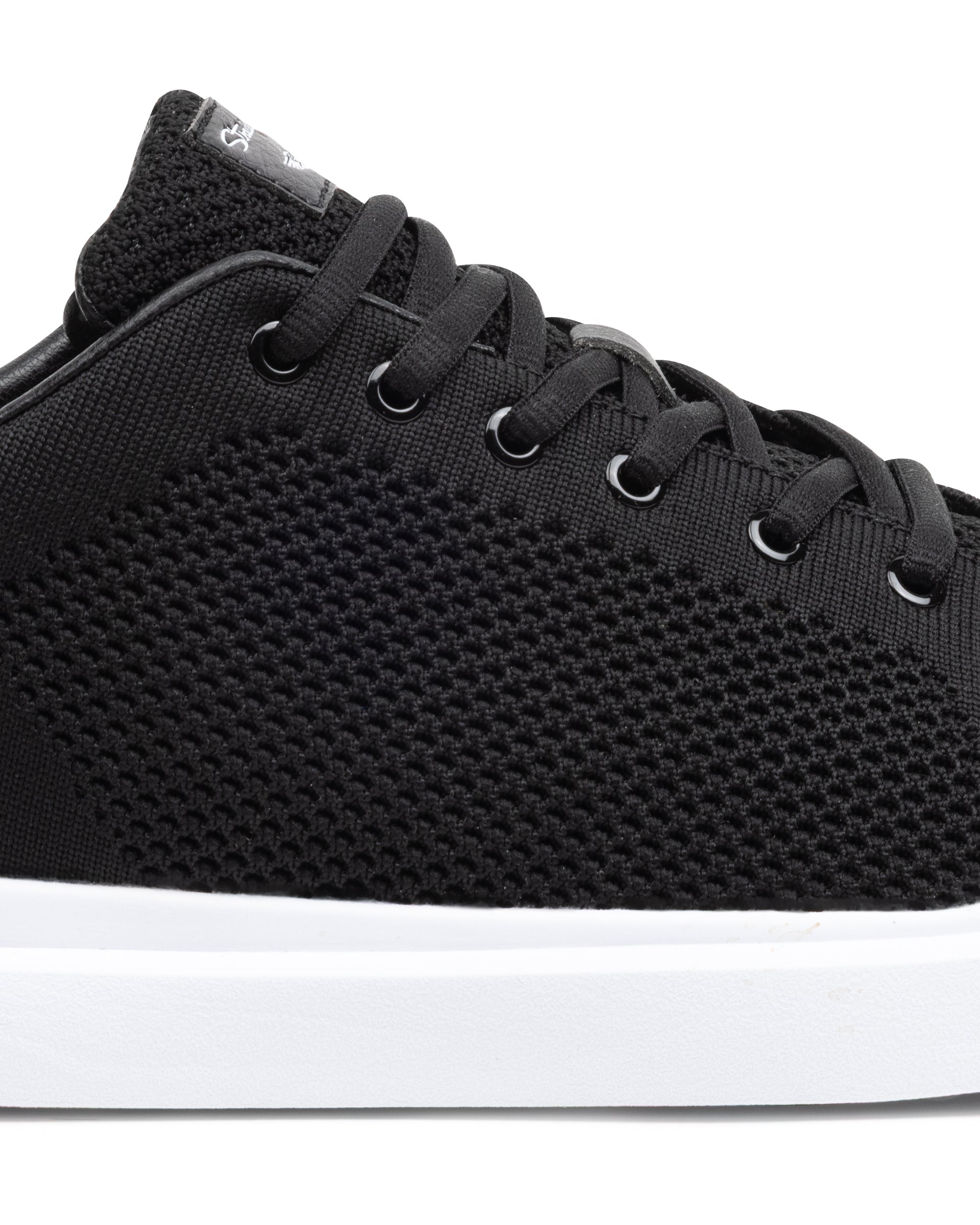 Black sneaker with white sole on a white background