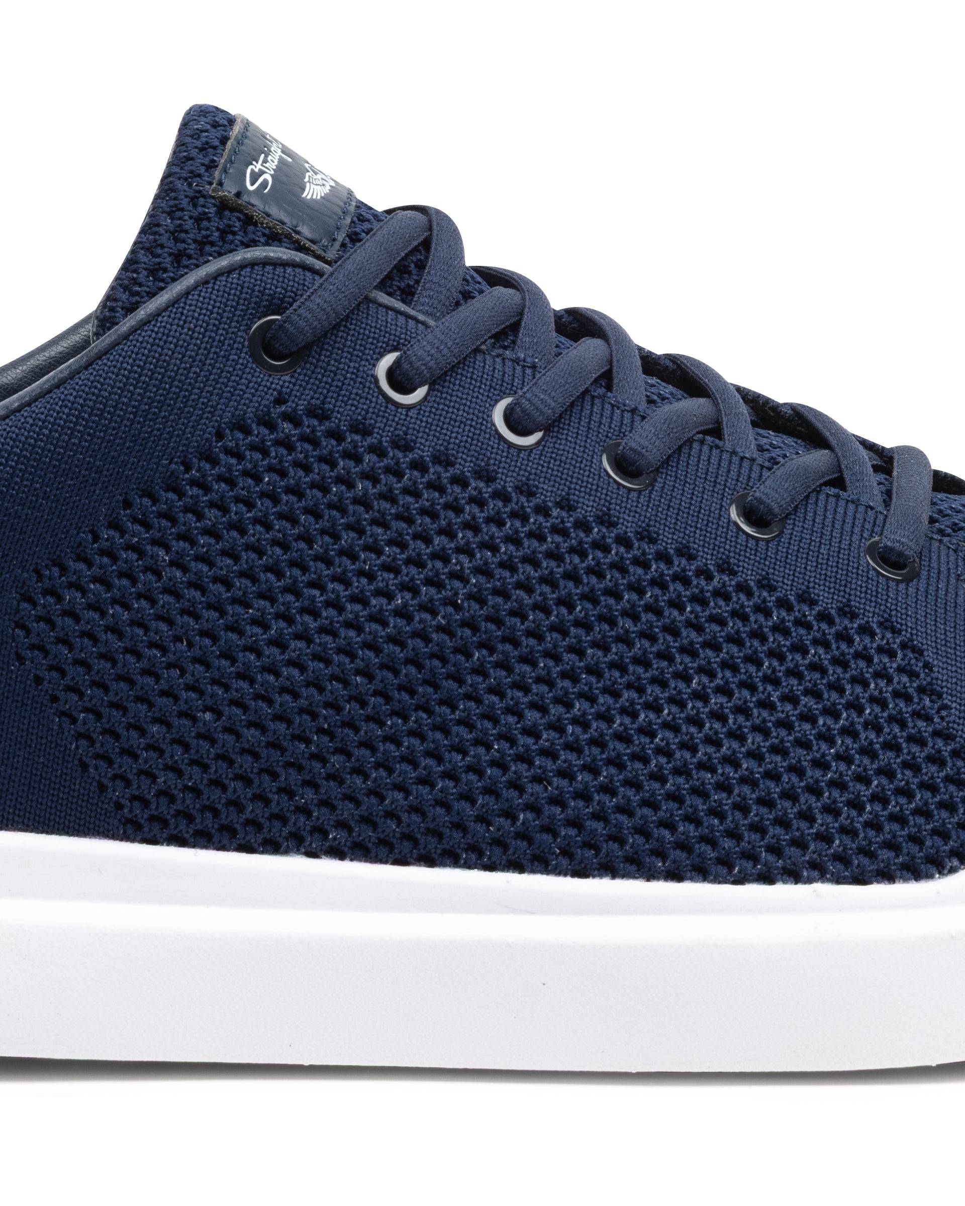 Navy blue sneaker with white sole on a white background