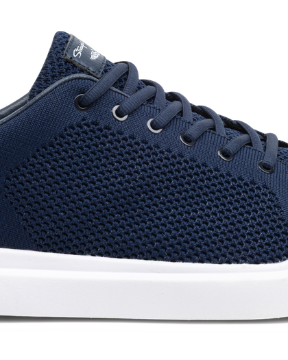 Navy blue sneaker with white sole on a white background