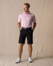 Men's Drake Short in Black, full-length front model view styled with a black belt, pink polo, and white golf shoes against a neutral canvas backdrop