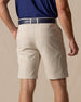 Men's Maverick Twill Short in Cashew, back model view featuring a light tan solid twill fabric with welt back pockets, styled with a navy polo and navy belt