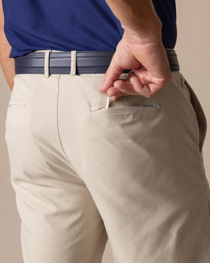 Men's Maverick Twill Short in Cashew, detail close-up back view featuring a light tan solid twill fabric with a welt back pocket, styled with a navy belt