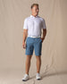 Men's Maverick Twill Short in Petrol, full length model view featuring a medium blue solid twill fabric, styled with a white polo, white belt, and white shoes