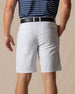 Men's Maverick Twill Short in Silver, back model view featuring a light gray solid twill fabric with welt back pockets and belt loops, styled with a navy striped polo and black belt