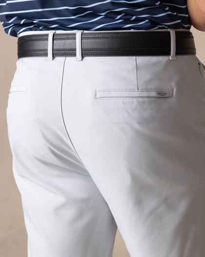 Men's Maverick Twill Short in Silver, detail close-up back view featuring a light gray solid twill fabric with a welt back pocket and tonal logo embroidery, styled with a black belt