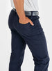 Men's Clemson Pant in Indigo, on-model close-up side view featuring a navy five-pocket style with a rear pocket, tonal embroidered logo, and a gray belt with silver buckle